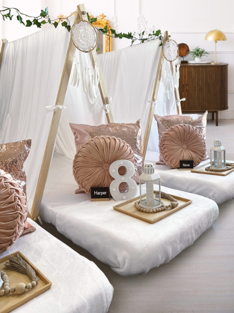 A row of white beds with pink pillows and numbers.