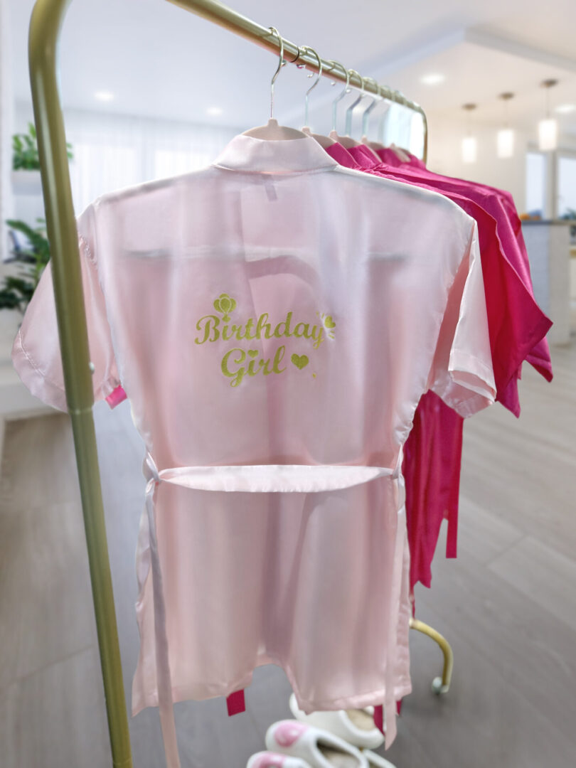 A pink robe with the words " birthday girl ".