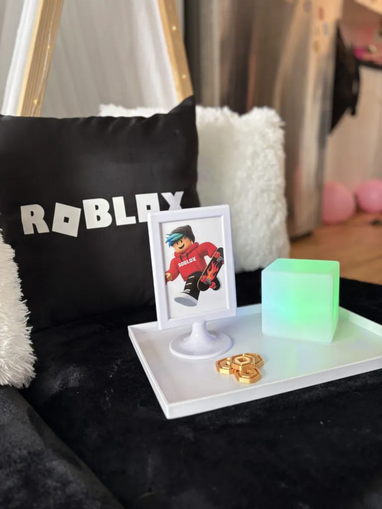 Roblox teepee slumber party setup with white teepees, black bedding, LED lights, and custom Roblox décor for a kids birthday sleepover party.
