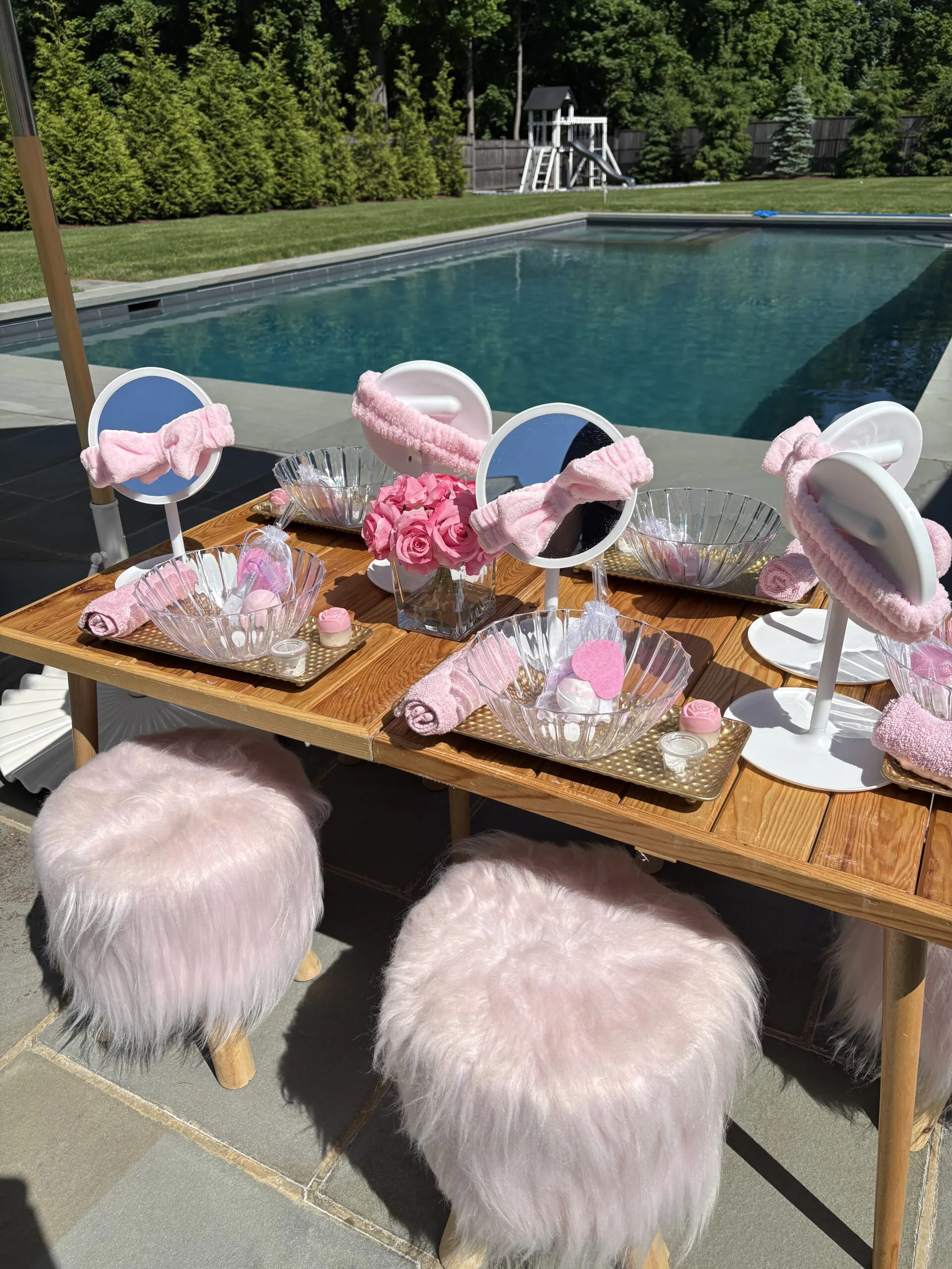 A colorful children’s spa party table with mirrors and pink decorations